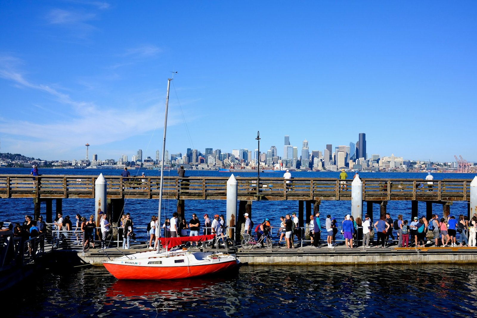 a group of people standing on a pier next to a boat